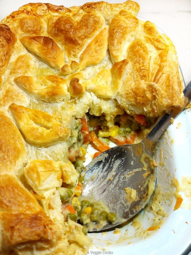 Vegan Vegetable Pie topped with puff pastry with a portion removed