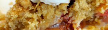 Rhubarb crumble on a plate with vegan cream