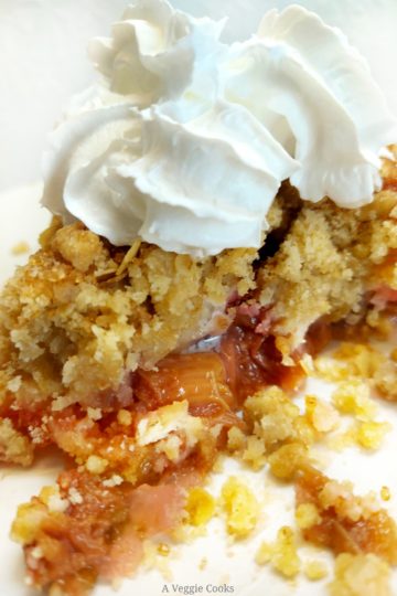 Rhubarb crumble on a plate with vegan cream