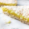 Vegan lemon slice topped with coconut on a white surface