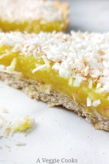 Vegan lemon slice topped with coconut on a white surface