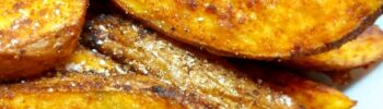 Spicy Potato Wedges piled up on a white plate