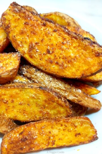 Spicy Potato Wedges piled up on a white plate