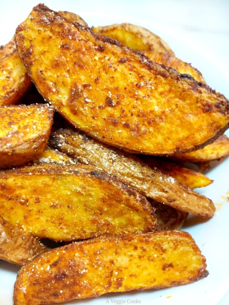 Spicy Potato Wedges piled up on a white plate