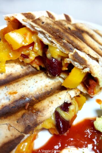 Cooked tortilla wrap with salsa, yellow pepper, kidney beans and vegan cheese
