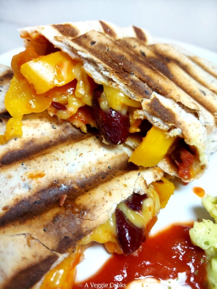 Cooked tortilla wrap with salsa, yellow pepper, kidney beans and vegan cheese