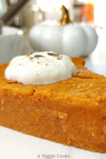 Slice of Vegan pumpkin pie with rest of pie in dish behind