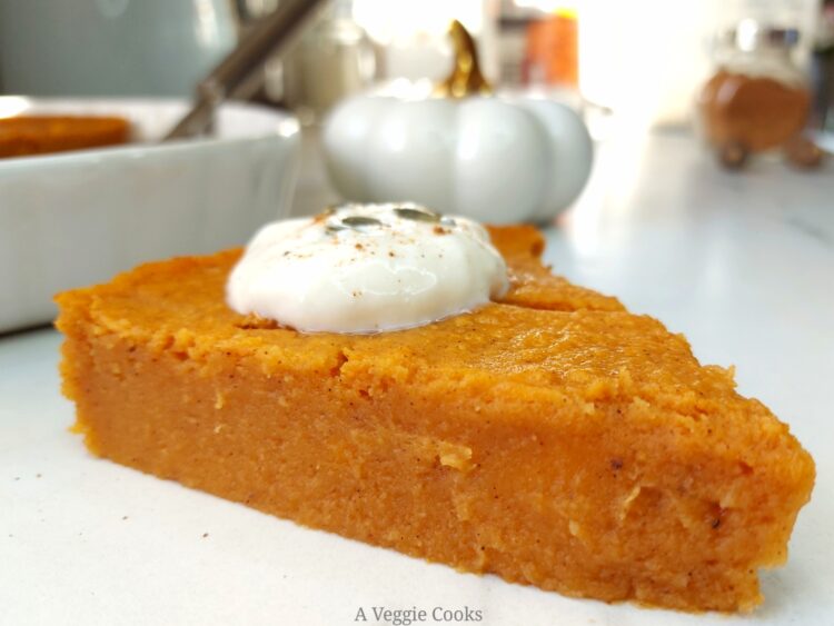 Slice of Vegan pumpkin pie with rest of pie in dish behind