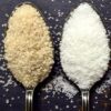 A spoon with white sugar and a spoon with brown sugar