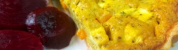 Slice of vegan quiche with sliced beetroot and tomatoes
