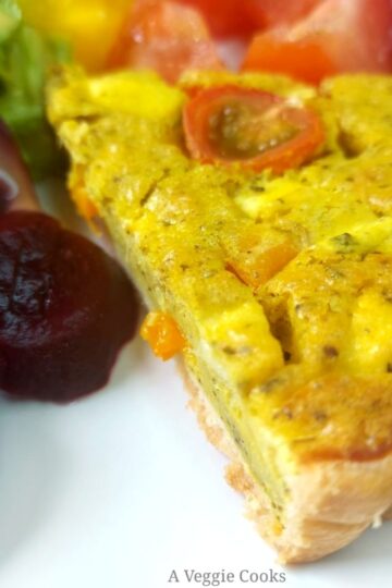 Slice of vegan quiche with sliced beetroot and tomatoes